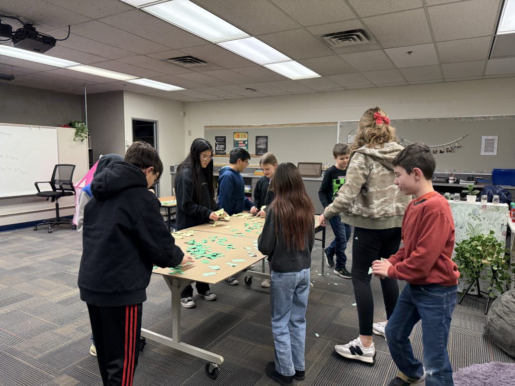 Students at Maple Grove Elementary work together to assemble one of the four moss wall frames for their cafeteria.